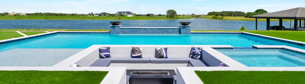 Luxury coastal home with resort-style pool, sunken outdoor lounge, and waterfront views