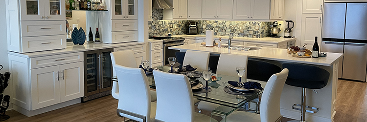 High-end kitchen renovation in Martin County featuring white shaker cabinets, quartz countertops, a stone mosaic backsplash, and a built-in wine cooler