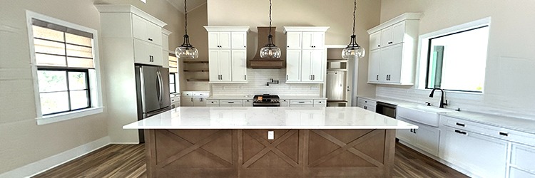 Spacious custom kitchen interior in a Martin County home featuring quartz countertops, white shaker cabinets, and hardwood floors by Masterpiece Builders