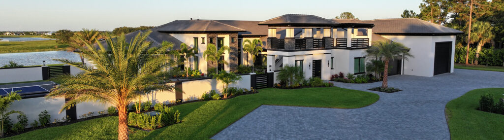 Luxury whole home remodel exterior in Martin County, FL, featuring modern architecture, waterfront views, and lush tropical landscaping by Masterpiece Builders