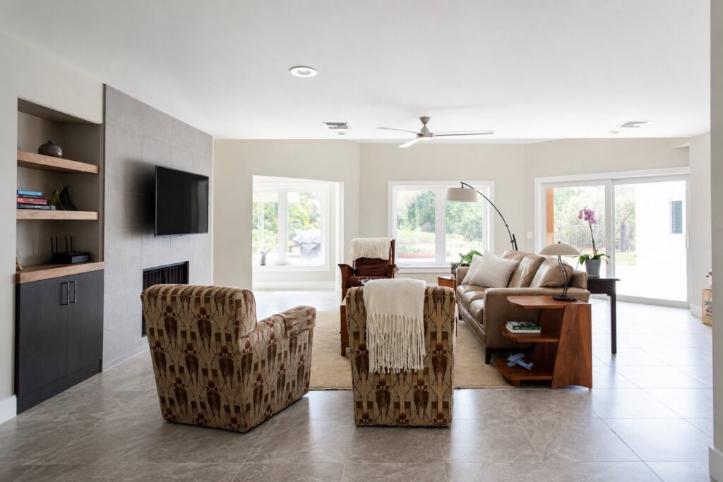 The same living room after renovation by Masterpiece Design/Build, leveled flush with the rest of the home on new porcelain tile